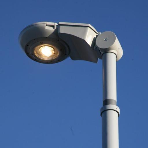 Een moderne straatlantaarn waarmee de armatuur variabel kan worden gekanteld. 27 Synchro LED-armatuur, in grijstinten tegen een blauwe lucht